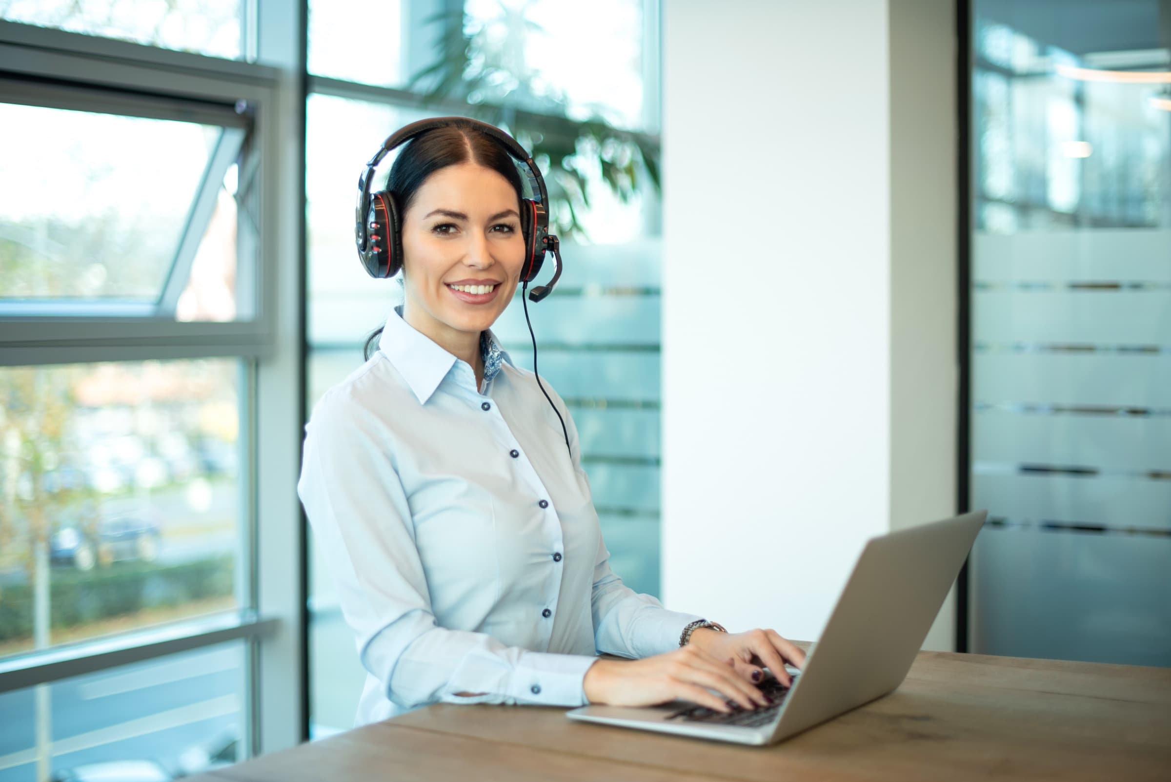 Support agent on a headset talking with a customer in a bright office